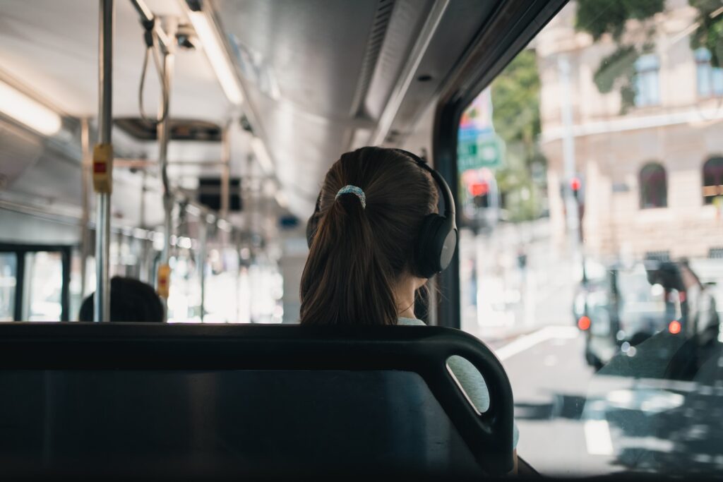 a woman with headphones sitting on a bus