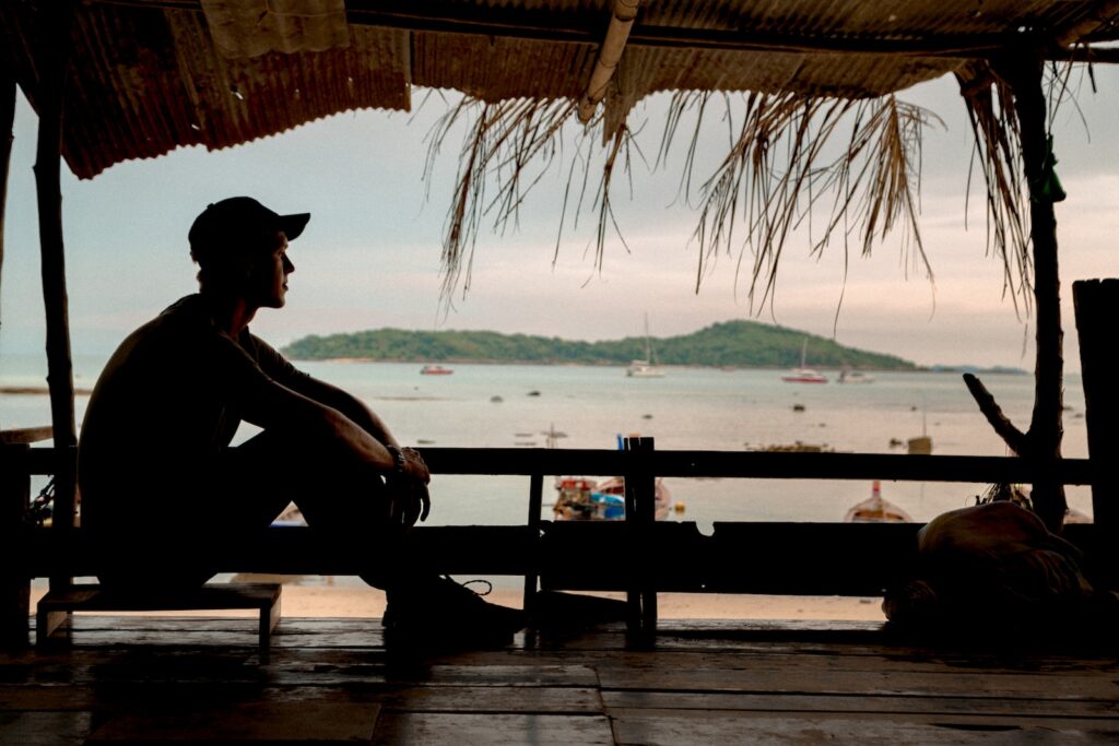 man sitting on chair at the cottage watching outside