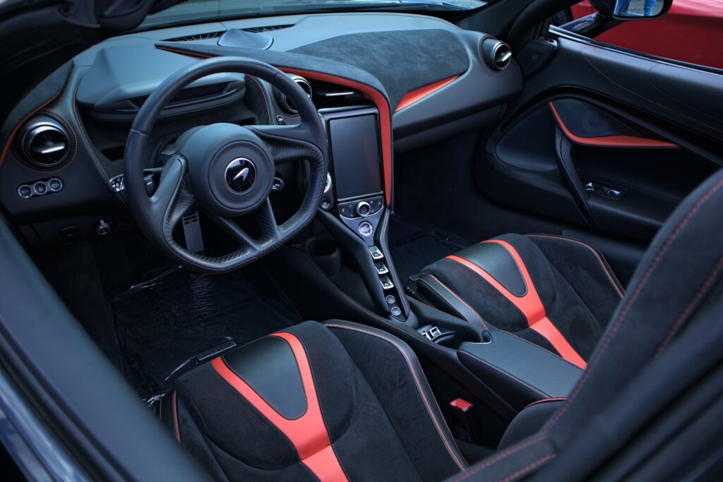 the interior of a sports car with red and black trim