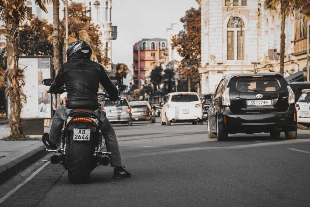 Man Wearing Jacket and Pants Riding On Motorcycle