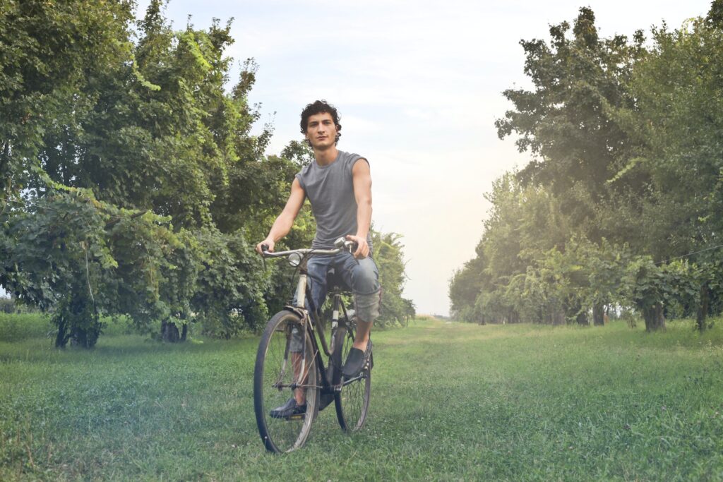 Man in Gray Sleeveless Shirt Riding Bike