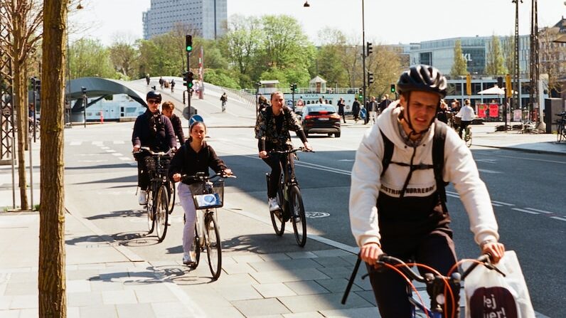 a group of people riding bikes down a street